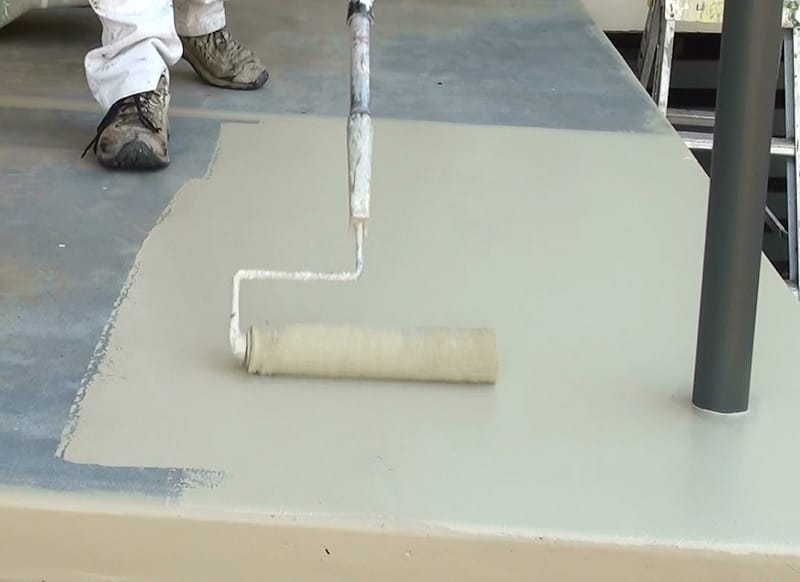 Roll coat flooring system being applied to a prepared surface.