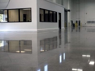A smooth, polished concrete floor reflecting light in a modern Pune building.