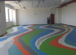 Designer metallic epoxy flooring with a swirling, reflective pattern installed in a modern Pune home.