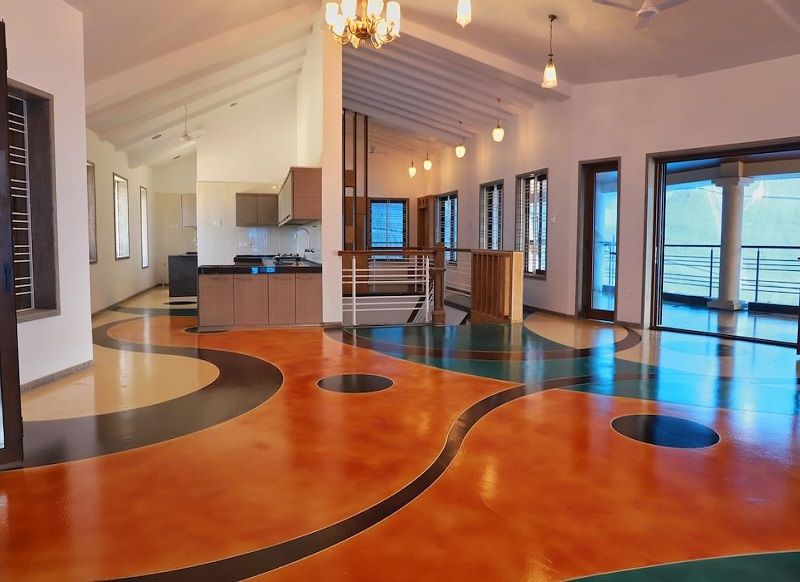 Stained concrete floor in a vibrant living room in India with earthy tones and a polished finish.